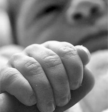 Newborn holding an adult finger